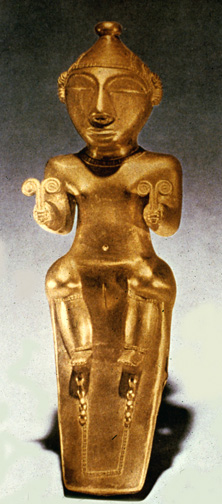 gold statue of seated goddess holding double spirals