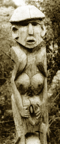 wooden statue of woman grasping her vulva