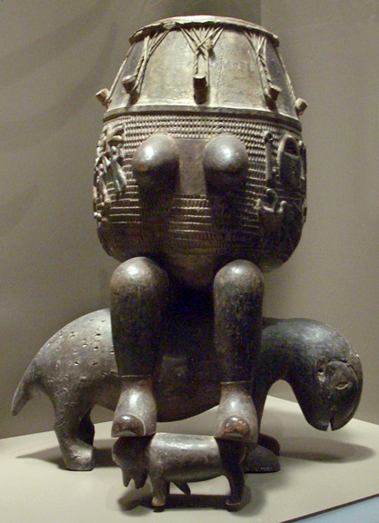 breasted drum with legs sitting on animal, carved in wood