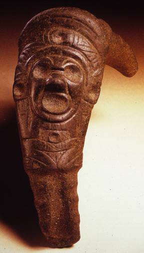 reddish stone elbow-stone with female figure carved in with vulva